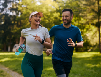 Happy athletic couple having fun while running together in nature
