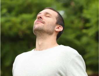 Man taking a deep breath with eyes closed